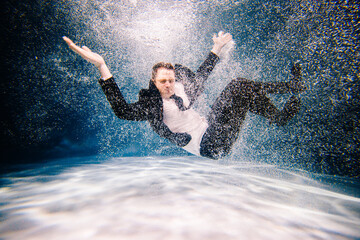 Man in black suite swimming in a pool. business man having fun in a pool. Office Worker drowing and sinking in a pool