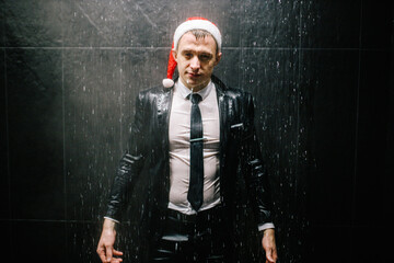 Man in black suit and white shirt taking shiwer. Office worker business man in shower. Man in christmass hat