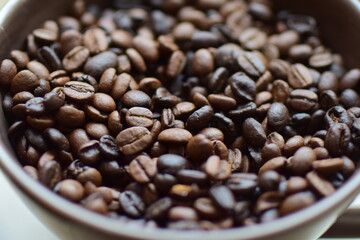 Roasted coffee beans in a cup as a close up