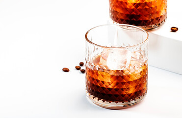 Black russian cocktail, trendy alcoholic drink with vodka, coffee liqueur and ice, white background, bar tools