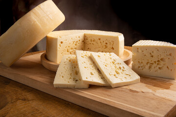 Semi-cured cheese from Brazil, beautiful Brazilian cheese arranged on light rustic wood, selective focus.