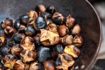 a pan of organic chestnuts grilled on the barbecue