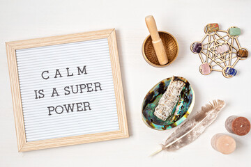Letter board with motivation text calm is a super power. Smudge kit with white sage and gemstones, crystals. Natural elements for cleansing environment, adding positive vibes. Mental health idea