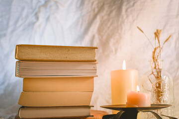 stack of old books and candles 