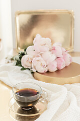 Styled composition with pink tulips on gold background. Floral frame and white textile. Border top view.