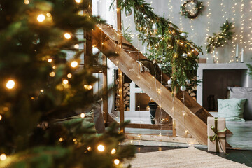 Home New Year's interior. A live Christmas tree and a wooden staircase in the kitchen. Cozy...