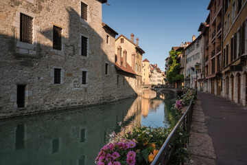 Medieval old town streets of Annecy and the reflection of the buildings in the water of the canal, France