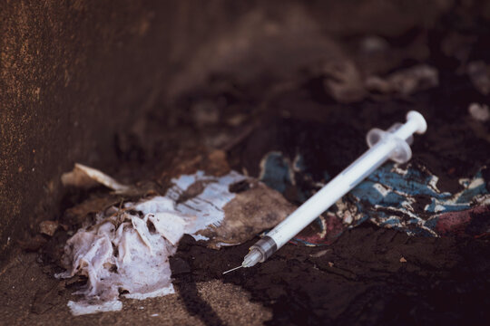 Discarded used hypodermic needle in gutter