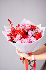Beautiful bouquet of mixed flowers in woman hand. Handsome fresh bouquet. Small flower shop and Flowers delivery.