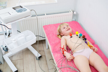 The child is being prepared for an electrocardiogram of the heart, diagnosis of heart disease in...