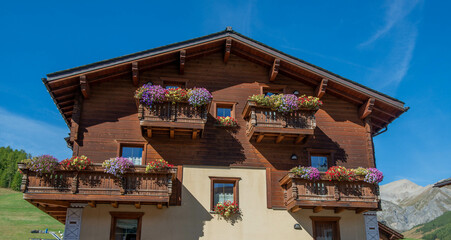 Wooden house with flowers on the balcony