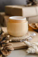  winter skin care cosmetic products with pine cones.  Opened face cream jar 