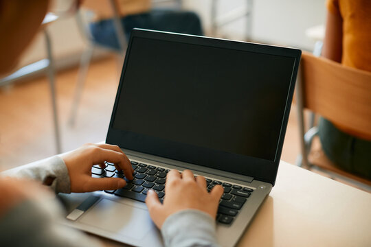 Close-up of student using laptop during computer class at high school.