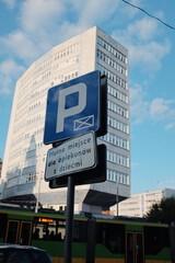 znak parking i w tle budynek