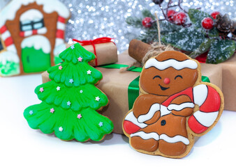 Christmas background with gifts and house cookies. Nuts with vanilla and cinnamon, a branch on the background.