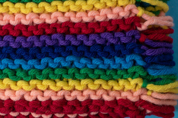 Fototapeta na wymiar hand knitting background featuring rainbow coloured super chunky yarn 