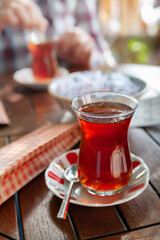 Turkish tea. A glass of tea on a table in a cafe in Istanbul. Tea in a traditional Turkish glass. Selective focus.