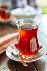 Turkish tea. A glass of tea on a table in a cafe. Close-up of tea in a traditional Turkish glass. Selective focus.