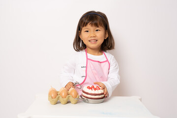 Beautiful little asian girl cooking isolate on white background