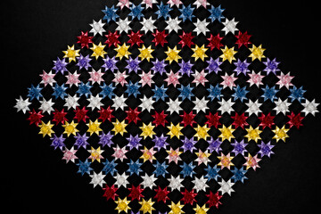 Folding paper stars on Black background.