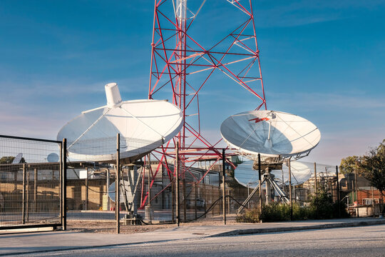 Two Satellites In Front Of A Radio Tower 