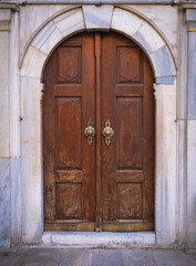 Fototapeta na wymiar old historic wooden door. marble arch and wall. arap camii, istanbul, turkey.