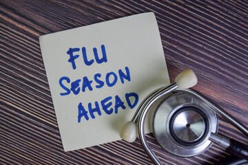 Flu Season Ahead write on sticky notes isolated on Wooden Table.