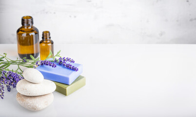 Spa and body care, aromatherapy and essential oil, herbal eco-friendly cosmetics concept. Natural homemade soap bars, glass bottles with massage oil and bunch of lavender flowers. Copy space