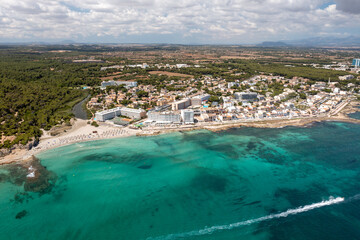Aerial drone photo of the beach front on the Spanish island of Majorca Mallorca, Spain viewed from above on a bright sunny summers day showing the beach front in the village of Can Picafort