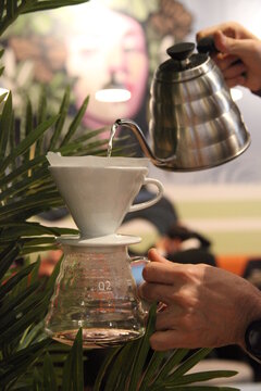 Barista pouring hot water in chemex. Alternative methods of brewing coffee. Brewing coffee in a chemex. Vertical soft focus shot.