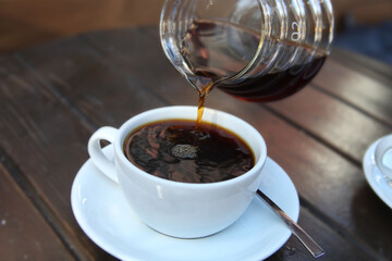 Barista pouring filter coffee into a cup. Brewing. Third wave. Americano.