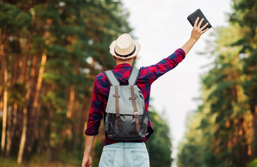 Christian man with outstretched hands holds a Bible in the open air. Faith, freedom, spirituality and religion concept