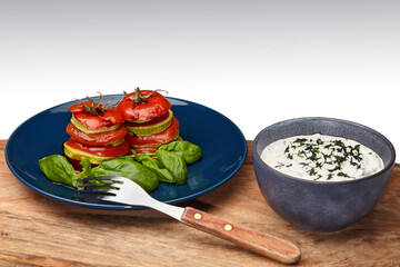 Baked tomatoes and zucchini with basil and sour cream sauce