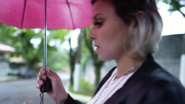 Woman opening umbrella outside during drizzle day