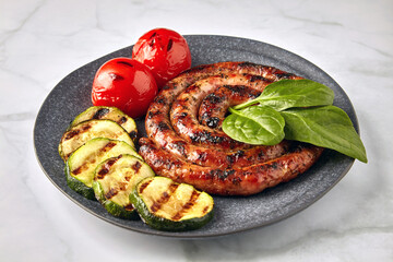 Grilled spiral sausage with zucchini, tomatoes and basil