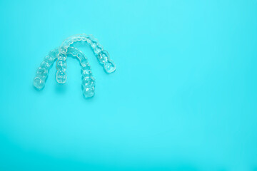 two transparent dental retainers on blue background