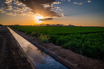 Irrigation canal or water channel in Tucson, Arizona next to farmland © mdurson