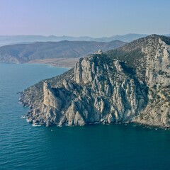 Panorama of cape Kaptchick, South Crimea. aerial photography. Blue sea and yellow rocks with green bushes. Camera straight down