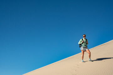 Hiker Poses On Steep Sand Dune