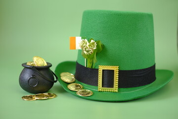 Saint Patrick background.Green leprechaun hat, flag,gold coins and blooming clover in a black...