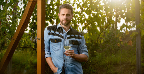 male vineyard owner. professional winegrower on grape farm. bearded man with wine glass