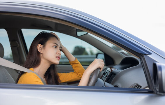 Young asian woman has broken down car on the road she feeling serious and stressed.Look for someone help. Driving during rush hour But the traffic is very congested.