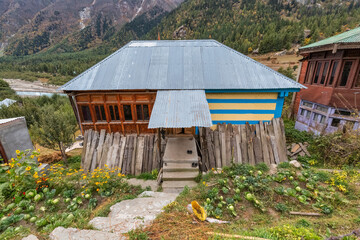 Rural village house on the mountain slopes with vegetable plants in the adjoining garden at Rakchham near Sangla Himachal Pradesh India
