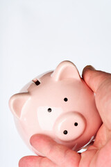 Piggy bank pink in hand on a white background. Close. Place for text