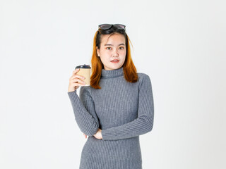 Portrait closeup studio shot of Asian young female model in gray turtleneck dress wear black lens shades on head standing smiling look at camera holding hot coffee cup crossed arm on white background