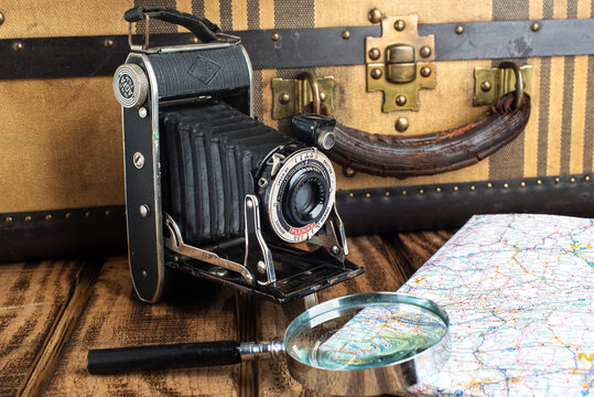 Old vintage Agfa camera with blurred background and old suitcase