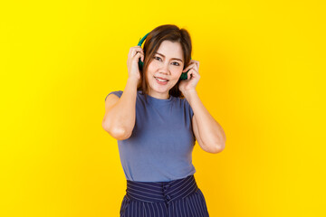 Beautiful and lively Asian woman on casual crop top enjoy listening music from headphone