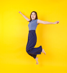 Beautiful Asian woman jumping freely in air for freedom fly as happy on independent and casual...