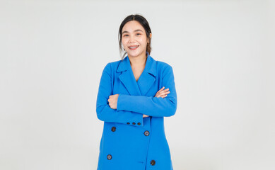 Beautiful young Asian woman cheerfully smile while standing with arm crossed on blue jacket uniform