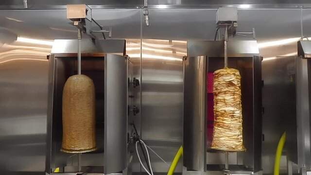 4k Loop4-4 Beef Donair on the left and Chicken Shawarma on the right rotating at a 360 degree rotation while being roasted perfectly as juices drip down the meat on a vertical BBQ doner Arabic cooking